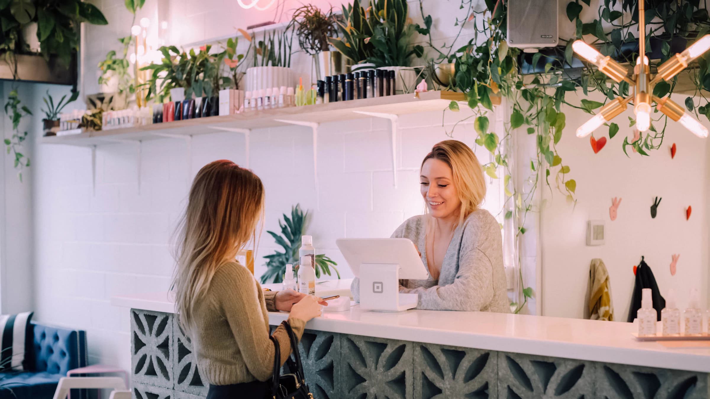 A smiling receptionist helps a patient at a bright front desk
